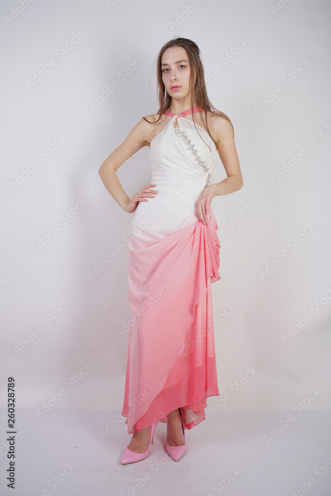 cute young teen girl stands in summer dress with pink Ombre on white background in Studio. cute young teen girl stands in summer dress with pink Ombre on white background in Studio.