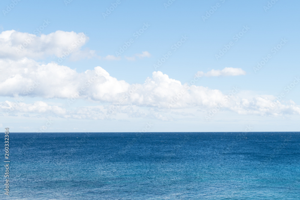 Clean, clear beautiful deep blue Atlantic Ocean backdrop wallpaper against a blue sky with few clouds and lots of copy space. Clean, clear beautiful deep blue Atlantic Ocean backdrop wallpaper against a blue sky with few clouds and lots of copy space.