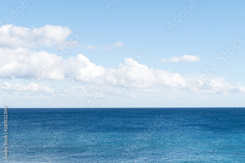 Clean, clear beautiful deep blue Atlantic Ocean backdrop wallpaper against a blue sky with few clouds and lots of copy space.  © Studio F.