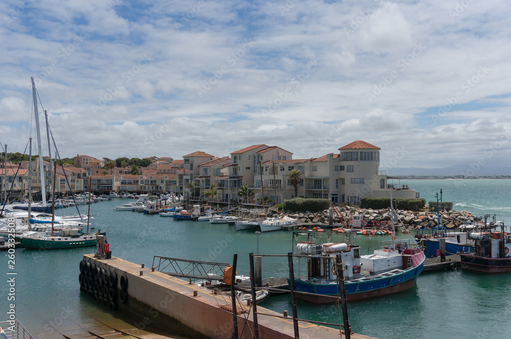 Fishing boats and yachts at harbour with residential houses