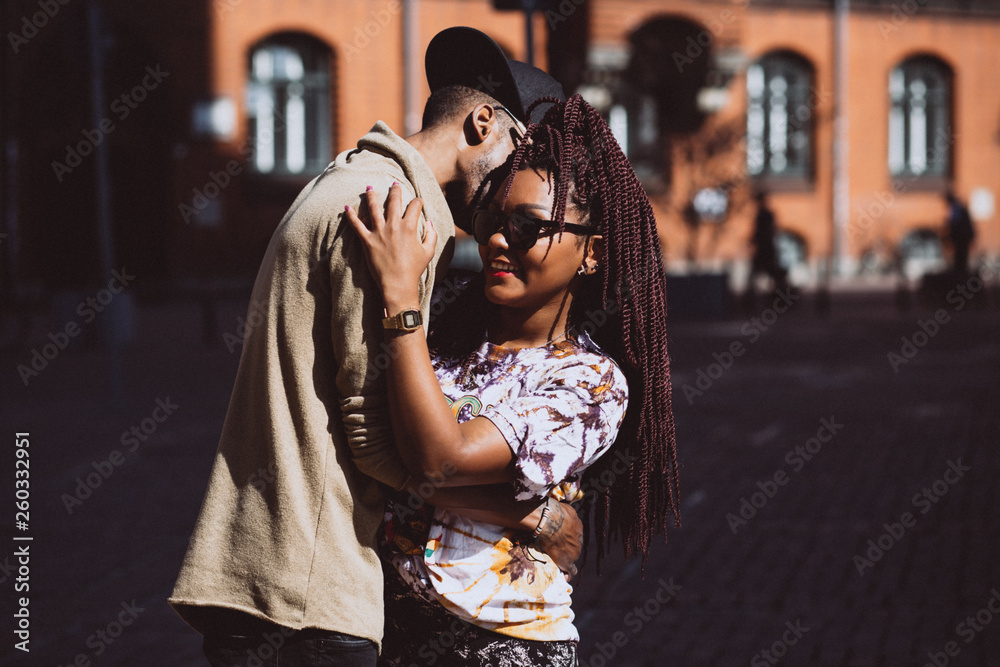 The love story of a guy and a girl on the city streets. Young people travel. Spring walk around the city. - obrazy, fototapety, plakaty 