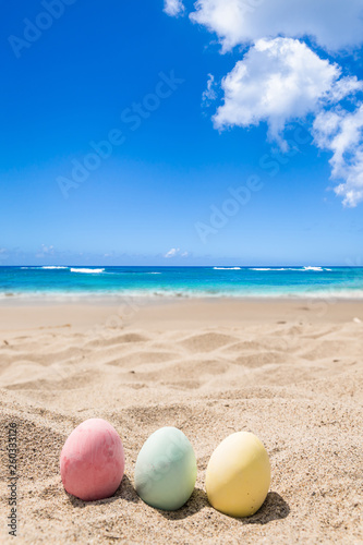 Easter bunny with color eggs on the ocean beach