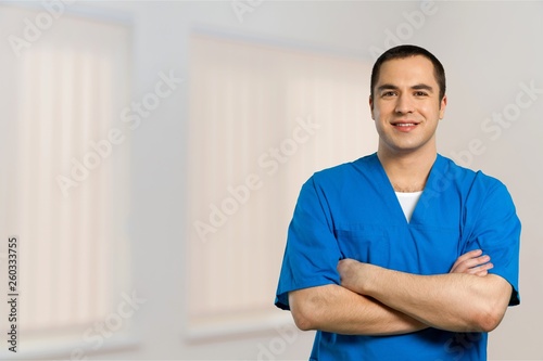 Young happy man doctor in blue uniform