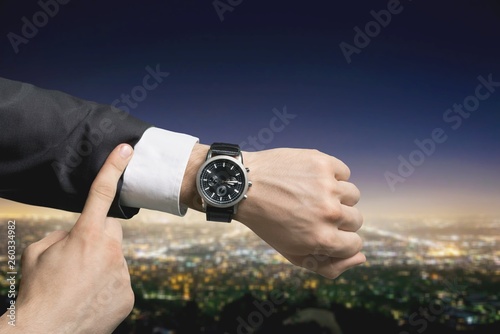 Businessman pointing at hand watch on white background, close-up