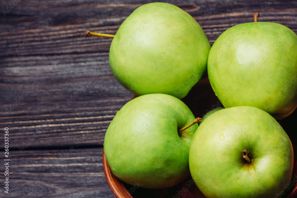 Beautiful ripe apples green in a bowl on a wooden table top view Beautiful ripe apples green in a bowl on a wooden table top view