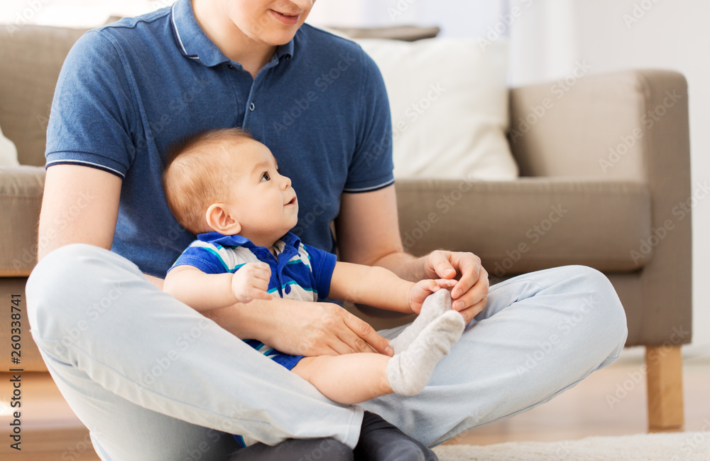 family, fatherhood and childhood concept - happy father with baby son sitting on floor at home family, fatherhood and childhood concept - happy father with baby son sitting on floor at home