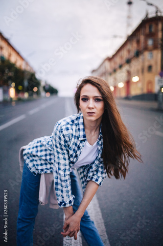 A girl standing in the middle of the roadway. Street urban style.