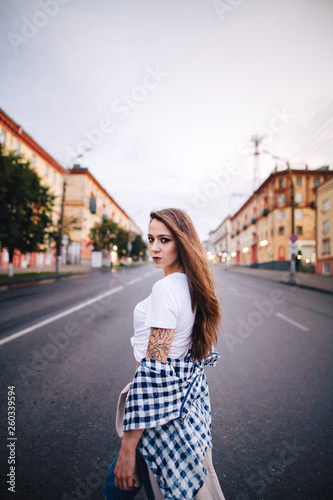 The girl turned around in the middle of the roadway. Girl in a plaid shirt and jeans. © mushegovdima