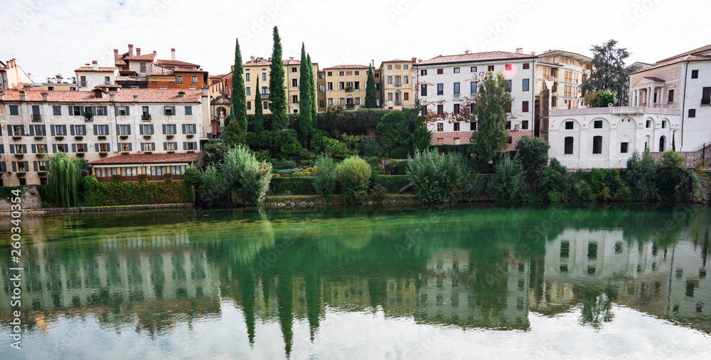 colorful houses  along river Brenta in Bassano del Grappa, Italy. With reflection in water