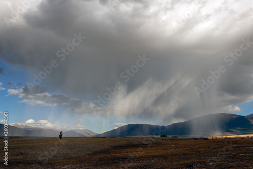 Wide angle view of a thunderstorm with rain shaft and anvil in the mountains