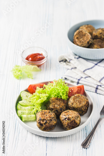 Vegan bean meatballs with vegetables and tomato sauce. Selective focus, space for text.