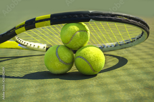 Tennis balls and racket on the grass court. Close-up. © IrynaV