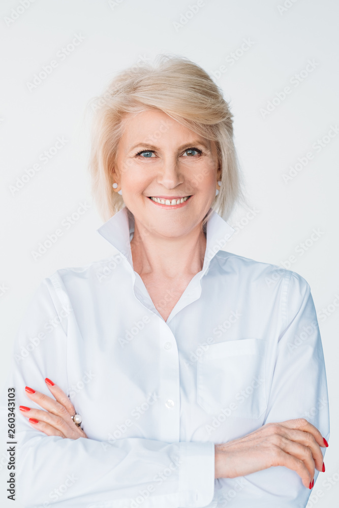 Smiling senior lady. Successful woman portrait. Emotion and facial expression. Professional posing with arms folded. Smiling senior lady. Successful woman portrait. Emotion and facial expression. Professional posing with arms folded.
