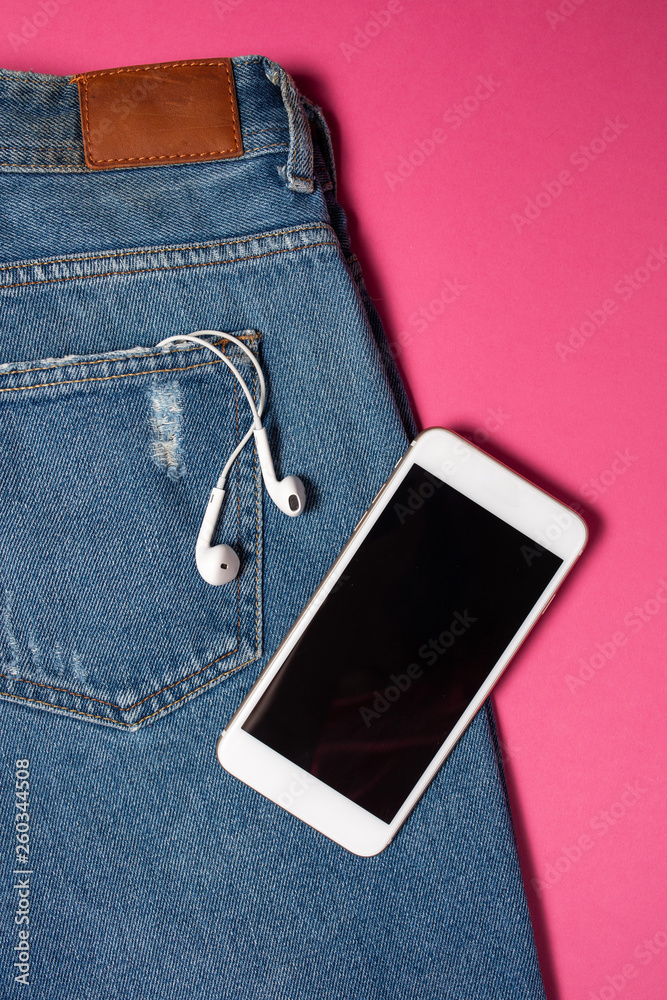 Flat background with copy space. Top view of casual woman outfit, jeans and headphones Flat background with copy space. Top view of casual woman outfit, jeans and headphones