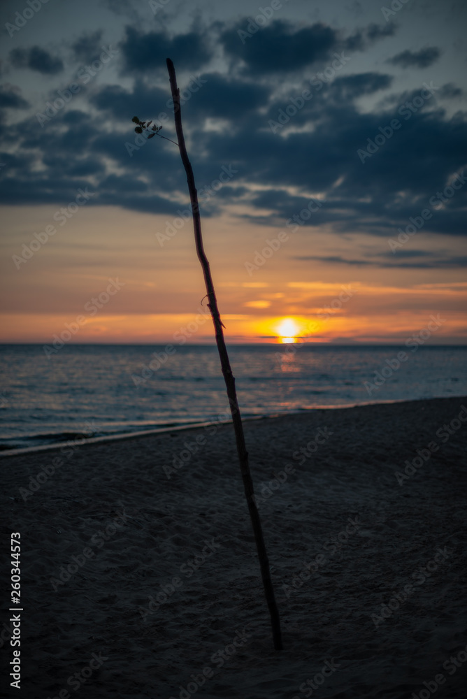colorful sunset over calm sea beach with dark blue water and dramatic contrasty clouds colorful sunset over calm sea beach with dark blue water and dramatic contrasty clouds