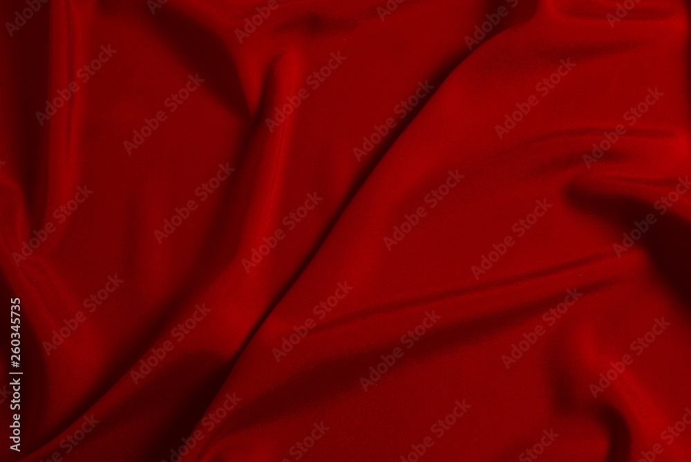 Red silk or satin luxury fabric texture can use as abstract background. Top view.