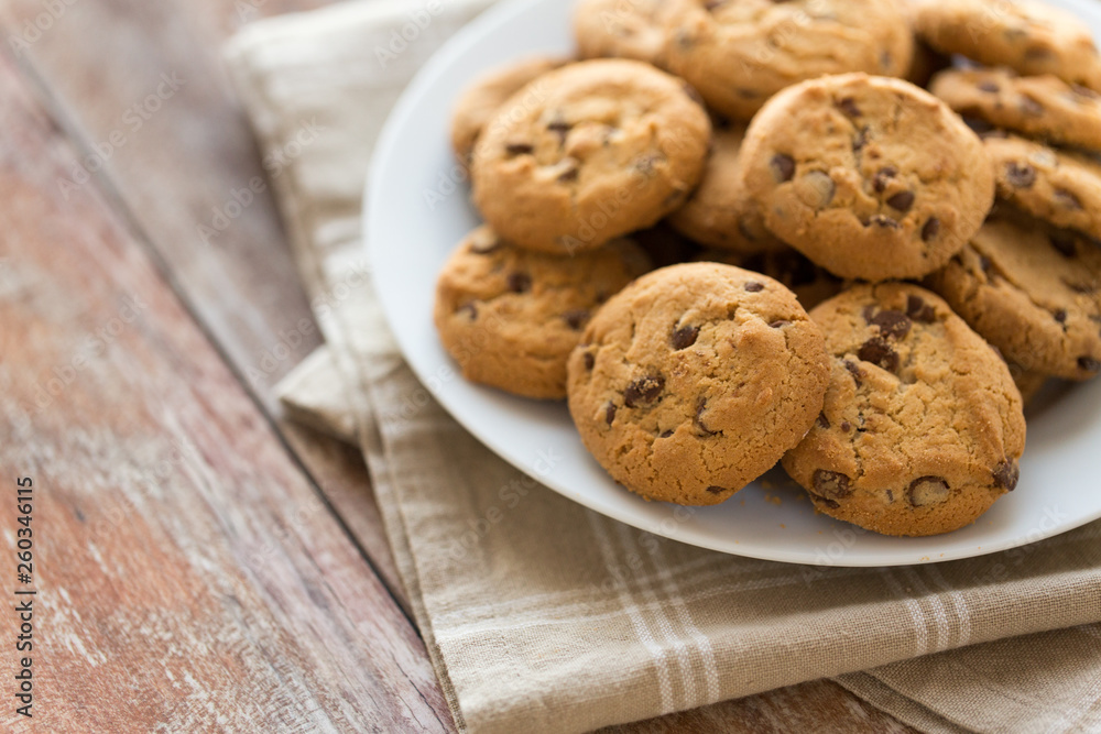food, junk-food and eating concept - close up of oatmeal cookies with chocolate chips on plate food, junk-food and eating concept - close up of oatmeal cookies with chocolate chips on plate