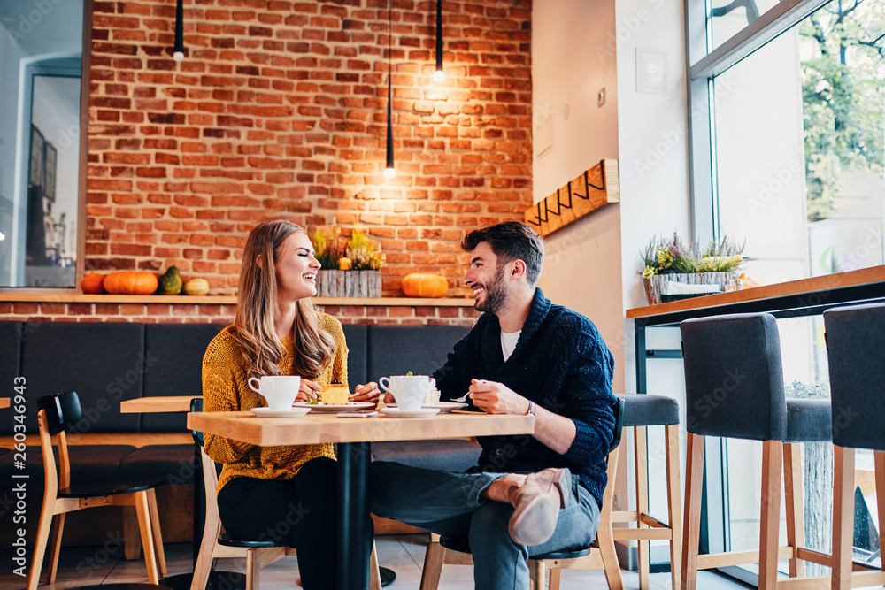 Picture of young couple dating at cafe. Young woman and man at coffee shop. - obrazy, fototapety, plakaty 