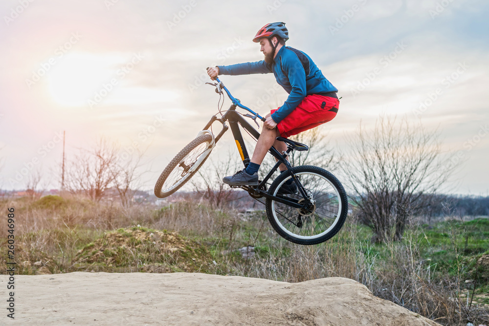 Man on a mountain bike performing a dirt jump. Active lifestyle.
