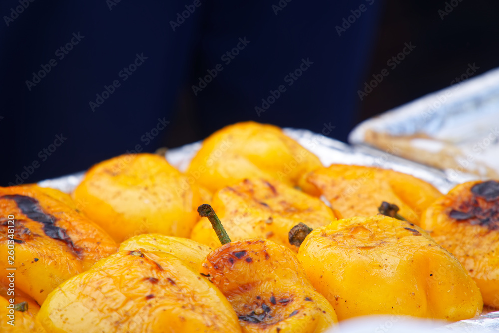 Grilled orange pepper sweet peppers on background, street food. Grilled orange pepper sweet peppers on background, street food.