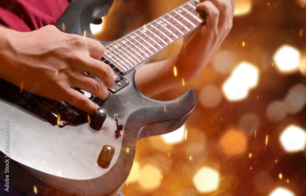 Fototapeta premium Male Guitarist playing music on background