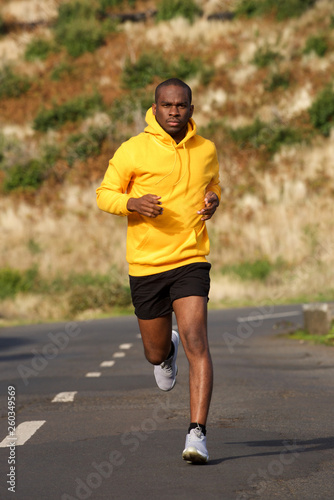 Full body healthy young african american man running on street