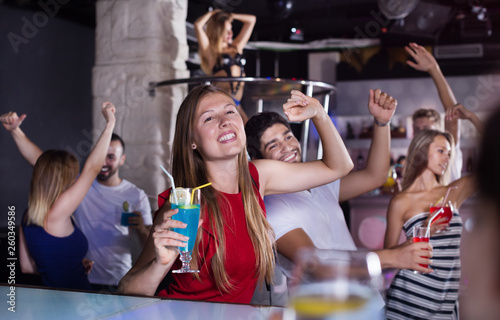 Woman dancing in the night club with drinks