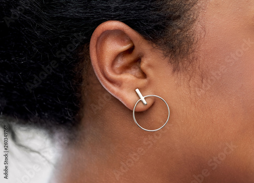 Obraz na plátne jewelry, piercing and people concept - close up of african american woman ear wi