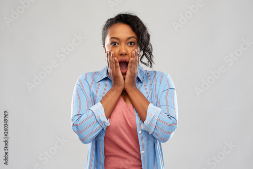 emotion, expression and people concept - shocked african american woman with open mouth over grey background
