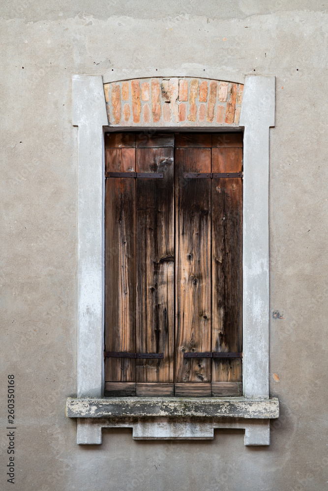 old wooden shutter in concrete wall, Rovigo, Italy