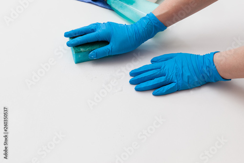 Detergents and cleaning accessories. Hand in a protective glove with a washing sponge. Cleaning service concept
