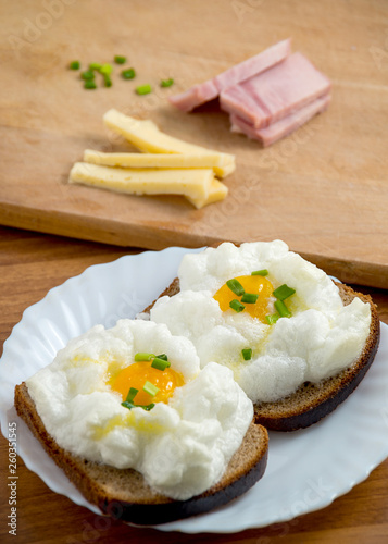 Orsini eggs on bread on wooden with cheese and ham