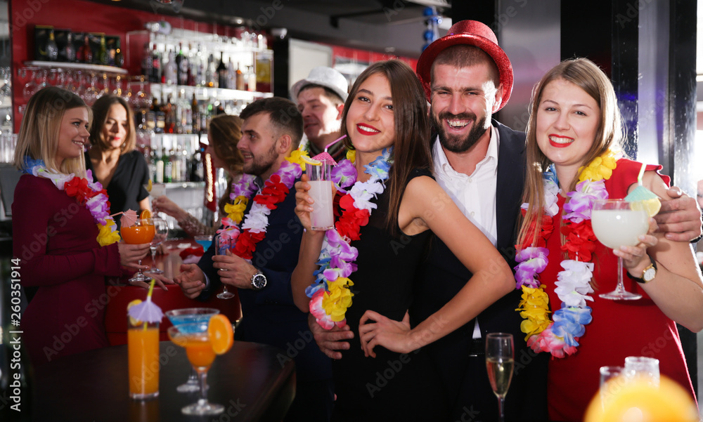 Man and two women on Hawaiian party at nightclub