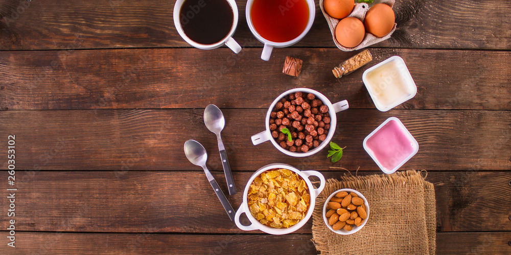 cornflakes, coffee, bread, butter, eggs, jam and other ingredients for breakfast on a dark background. Top view with copy space cornflakes, coffee, bread, butter, eggs, jam and other ingredients for breakfast on a dark background. Top view with copy space