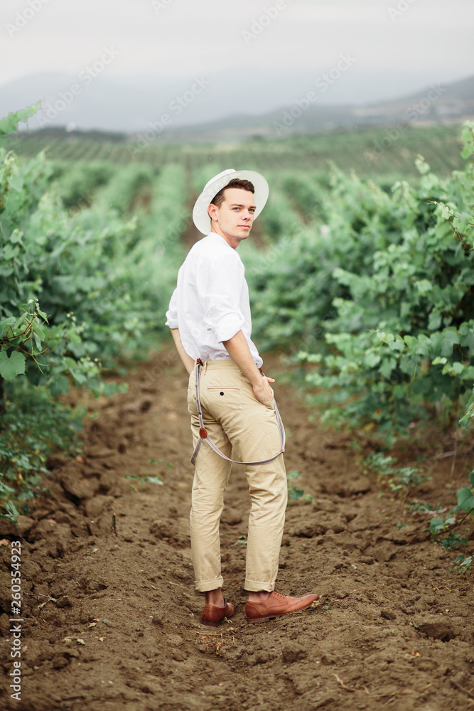 Fototapeta premium Portrait of a gorgeous women and man in the vineyards.