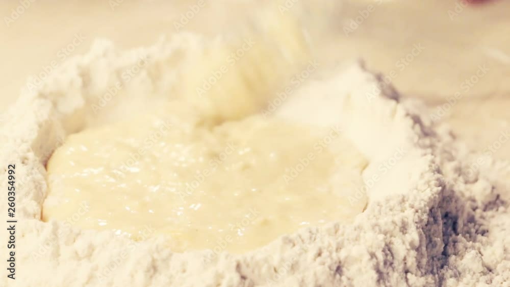 Cooking. Working dough from white four and eggs (or liquid). Closeup. Home baking, bakery, pastry, bread concept. Selective focus. Cooking. Working dough from white four and eggs (or liquid). Closeup. Home baking, bakery, pastry, bread concept. Selective focus.