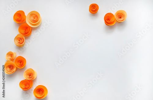 Colorful handmade paper flowers on light coloured background for invitation and wedding