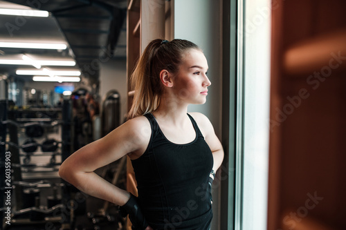A portrait of young girl or woman standing in a gym.
