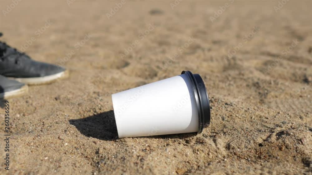 woman raises coffee paper cup from the beach woman raises coffee paper cup from the beach