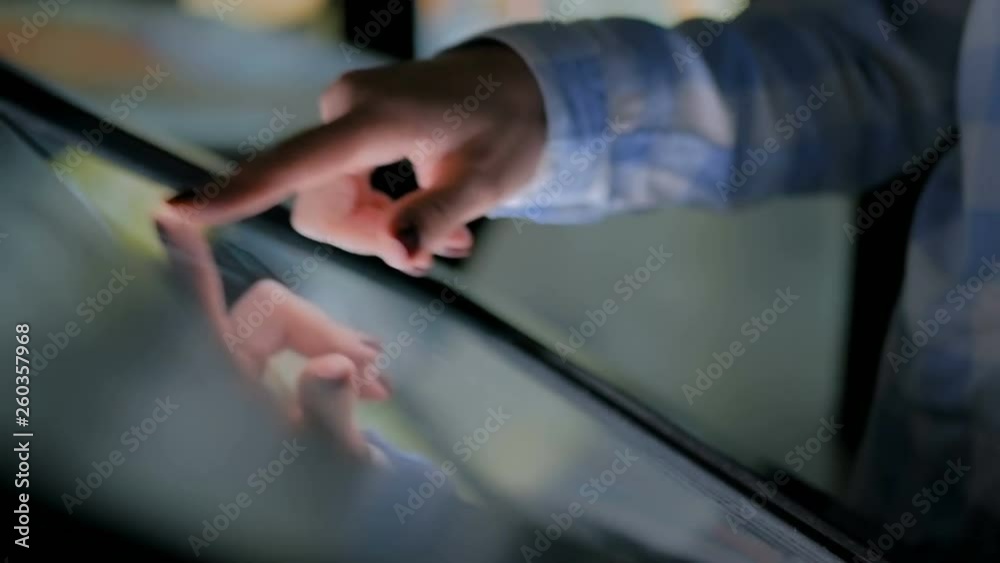 Education and technology concept - woman using interactive touchscreen display of electronic kiosk at modern history museum - close up shot