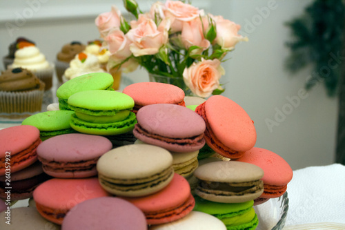 colorful Macarons cakes on a platter with rose as background