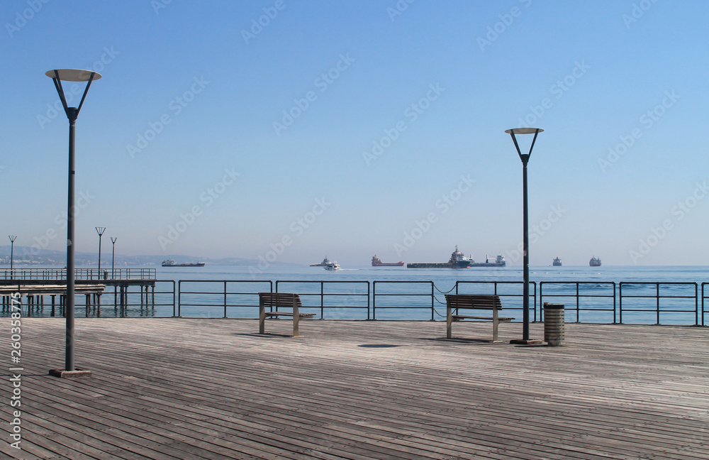 Empty benches with a seaview and the street lamps on a wooden pier