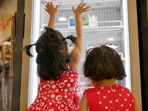 Wallpaper Mural Little Asian baby girls, sisters, looking and touching the bakery fridge as they were irresistibly hungry for beautiful cakes Torontodigital.ca
