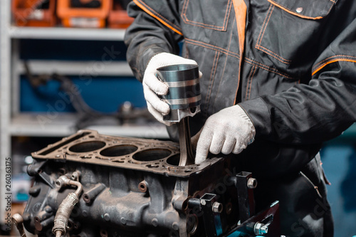 Behang Car mechanic holding a new piston for the engine, overhaul