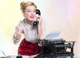 Attractive young woman working on vintage typewriter
