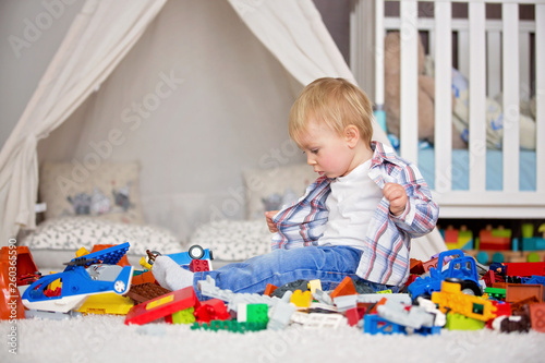 Child toddler playing with construction toys at home