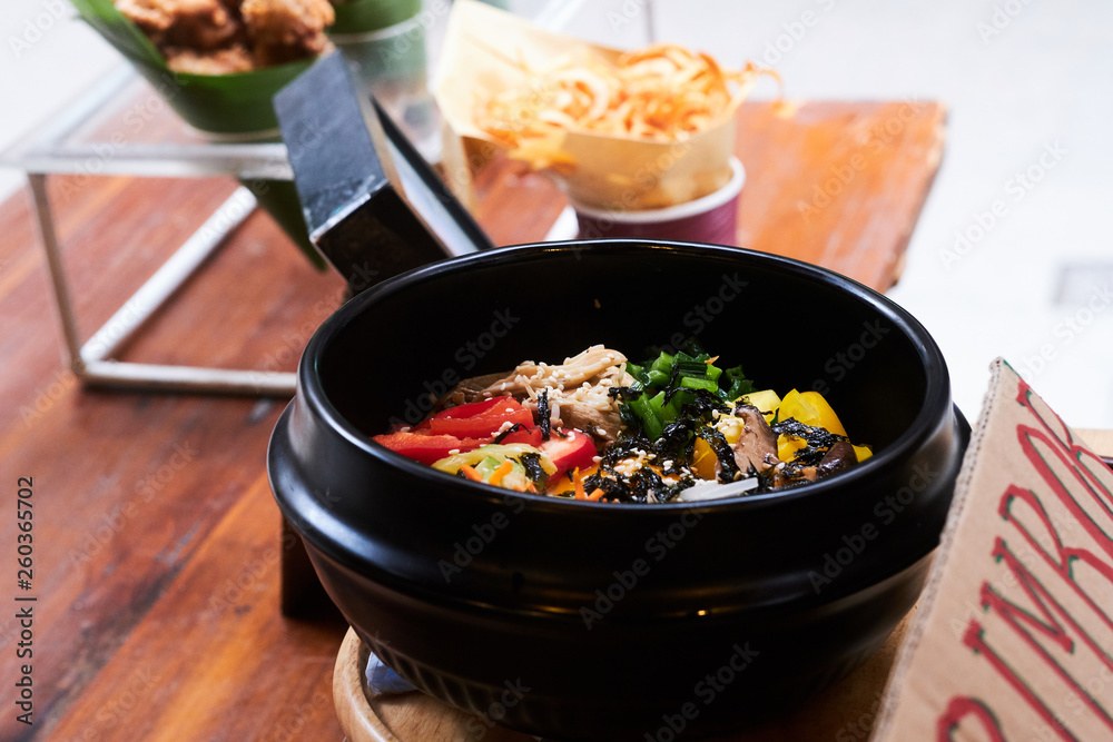 Asian dish in black bowl with vegetables