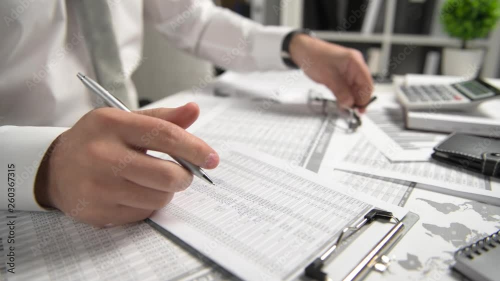 Businessman working at office and calculating finance, reads and writes reports. Business financial accounting concept.