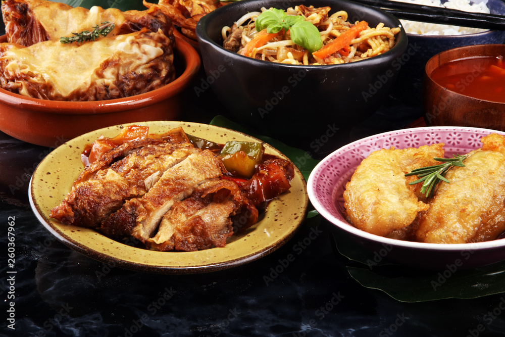 Assorted Chinese food set. Chinese noodles, fried rice, peking duck, dim sum, spring rolls. Famous Chinese cuisine dishes on table. Chinese restaurant Assorted Chinese food set. Chinese noodles, fried rice, peking duck, dim sum, spring rolls. Famous Chinese cuisine dishes on table. Chinese restaurant