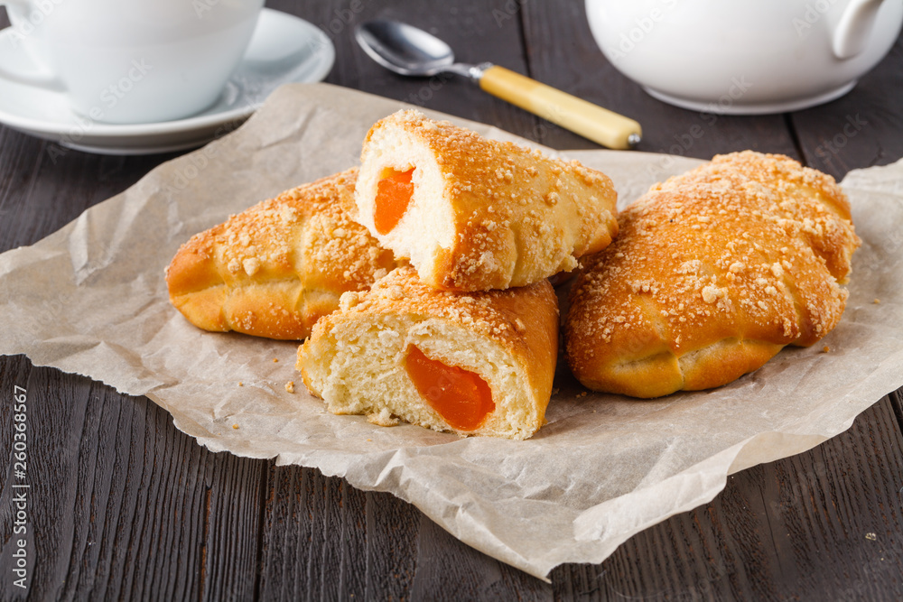 Biscuit rolls filled with jam with powdered sugar on top on plate over wooden table Biscuit rolls filled with jam with powdered sugar on top on plate over wooden table